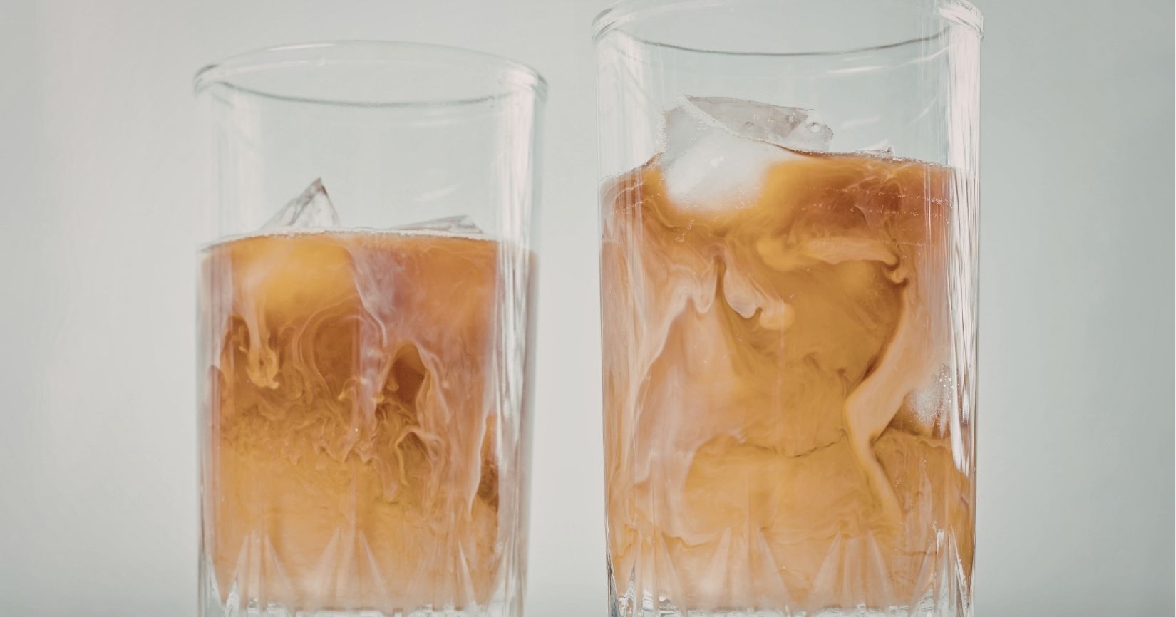 An iced latte and an iced coffee side by side showing the color and milk difference