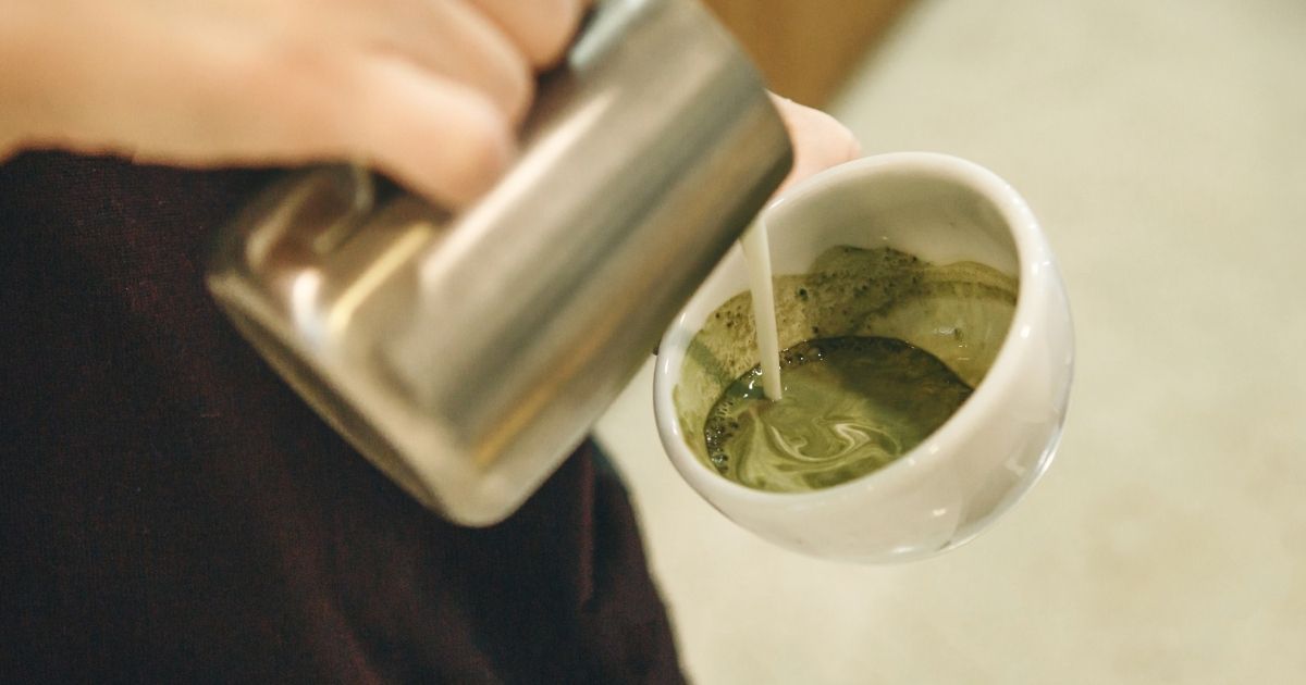 A green matcha latte and a warm chai latte side by side